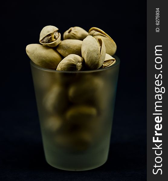 Pistachio nuts in a shot glass. Pistachio nuts in a shot glass