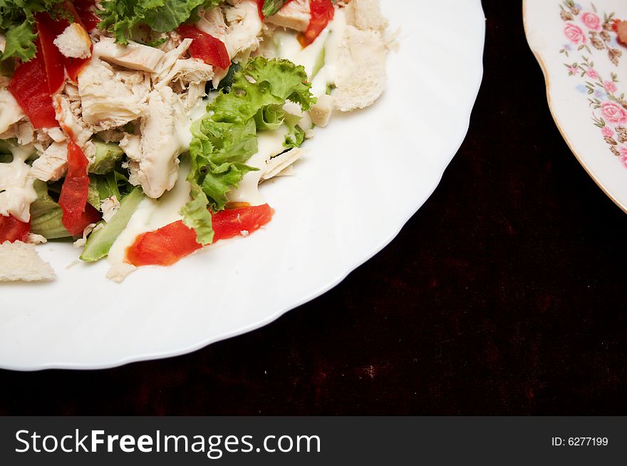 Salad from meat and vegetables on the white plate. Salad from meat and vegetables on the white plate