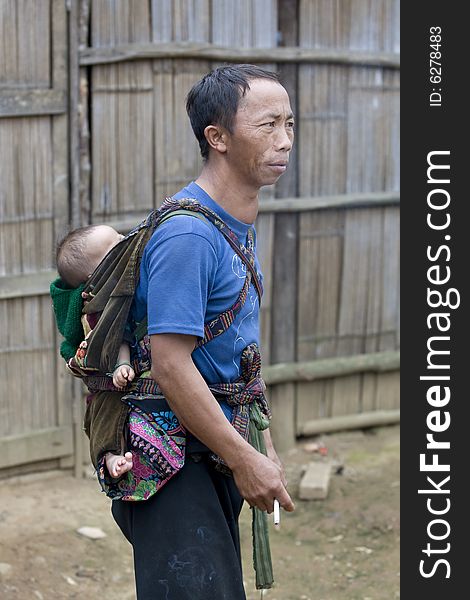 Father with baby in Laos carries his child at the back