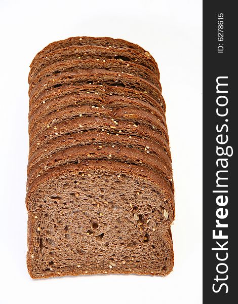 Stack of sliced wheat bread on white table.