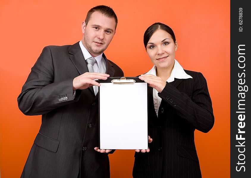 Businesspeople holding blank paper on orange background. Businesspeople holding blank paper on orange background