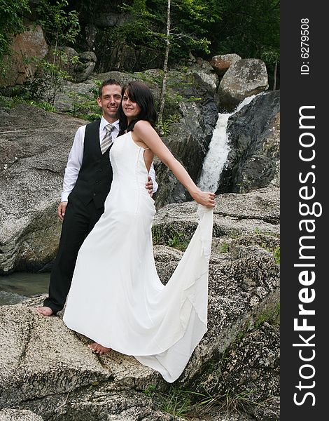 Happy bride and groom standing on top of a mountain.