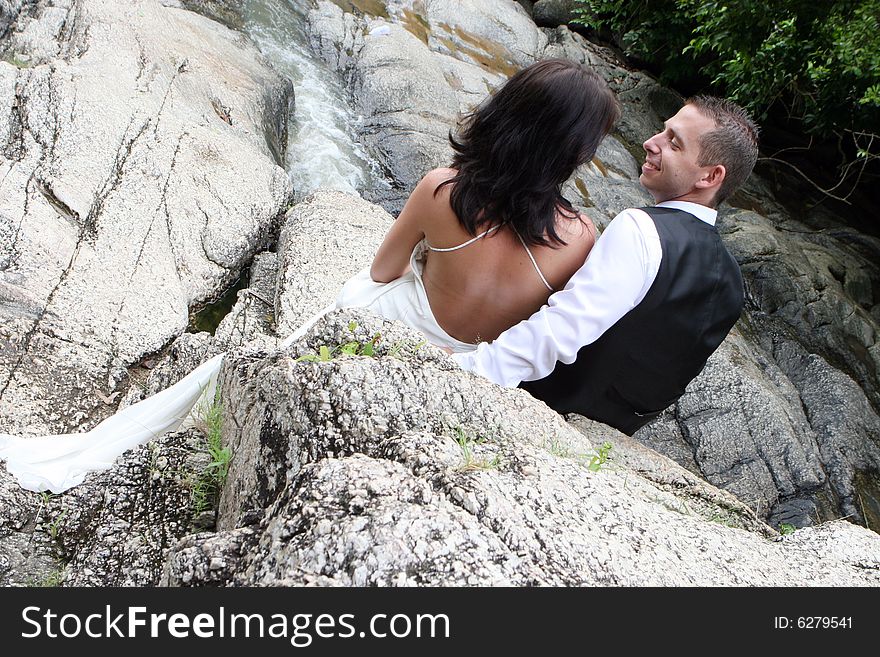 Happy bride and groom standing on top of a mountain.