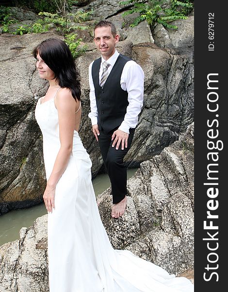 Happy bride and groom standing on top of a mountain.