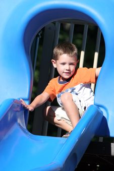 Young Boy At The Top Of A Shiny Blue Slide Royalty Free Stock Photography Young Boy At The Top Of A Shiny Blue Slide Royalty Free Stock Photography