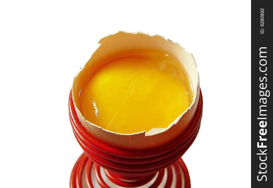 Broken egg in a egg cup on white background. Broken egg in a egg cup on white background