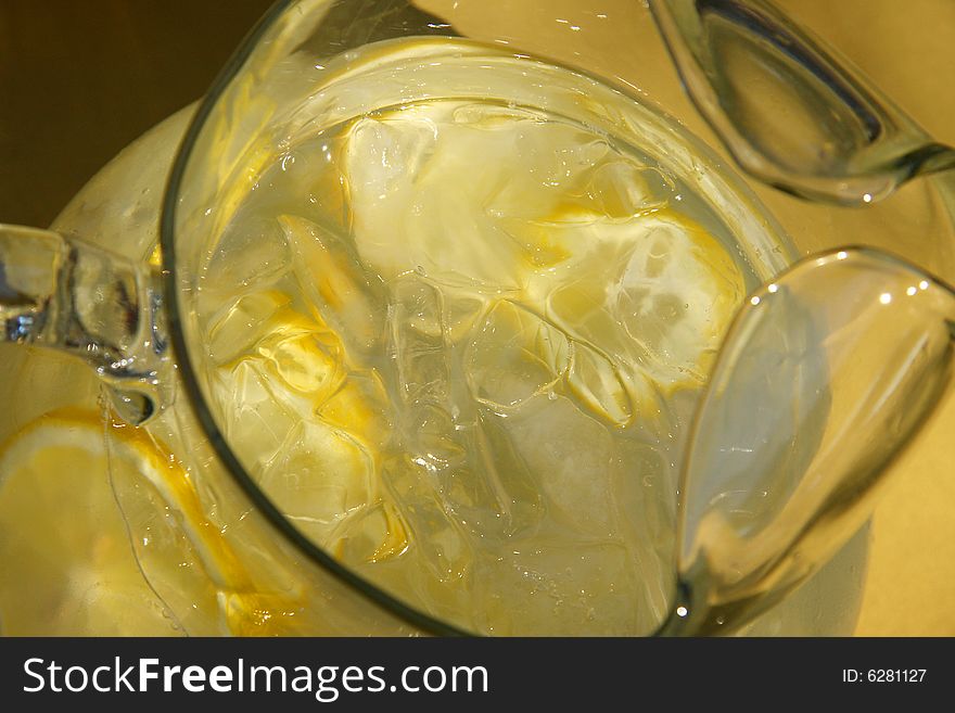 Pitcher of lemonade with lemon slices and ice cubes