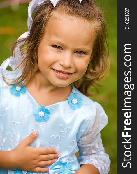 Portrait of little girl in blue dress on the green grass. Portrait of little girl in blue dress on the green grass