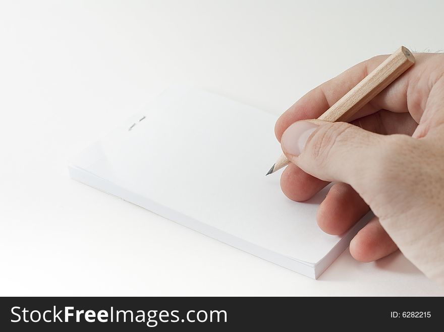 Right hand using a small pencil to write on a blank paper. Right hand using a small pencil to write on a blank paper.