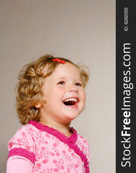 Small laughing girl in rose dress