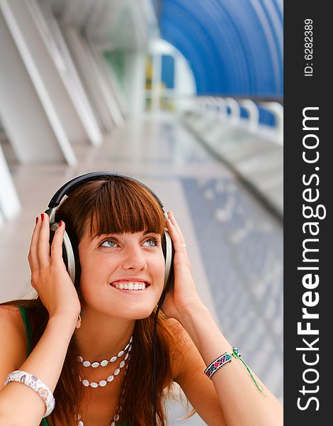Smiling girl listening to music in big headphones. Smiling girl listening to music in big headphones