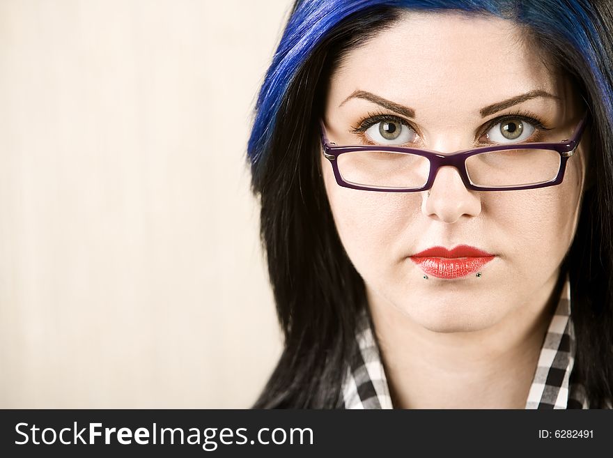 Portrait of a cute rockabilly woman looking over her glasses. Portrait of a cute rockabilly woman looking over her glasses