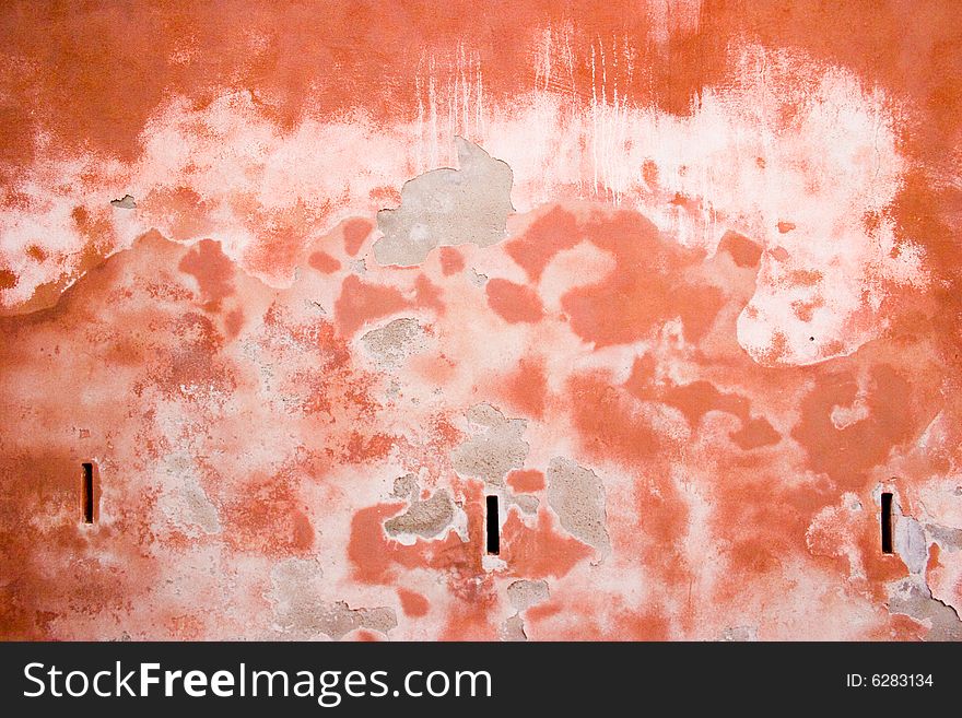 Closeup of red-brown old wall with peeled stucco and stains. Closeup of red-brown old wall with peeled stucco and stains