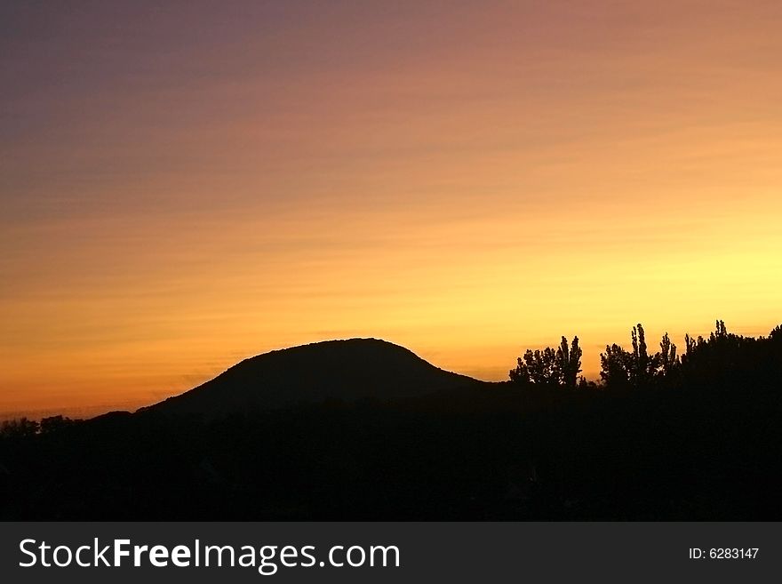 Sunset above only hill in the scene. Sunset above only hill in the scene