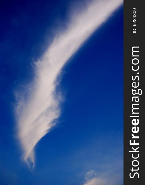 Unusual swirling twisting cloud with a blue sky background. Unusual swirling twisting cloud with a blue sky background