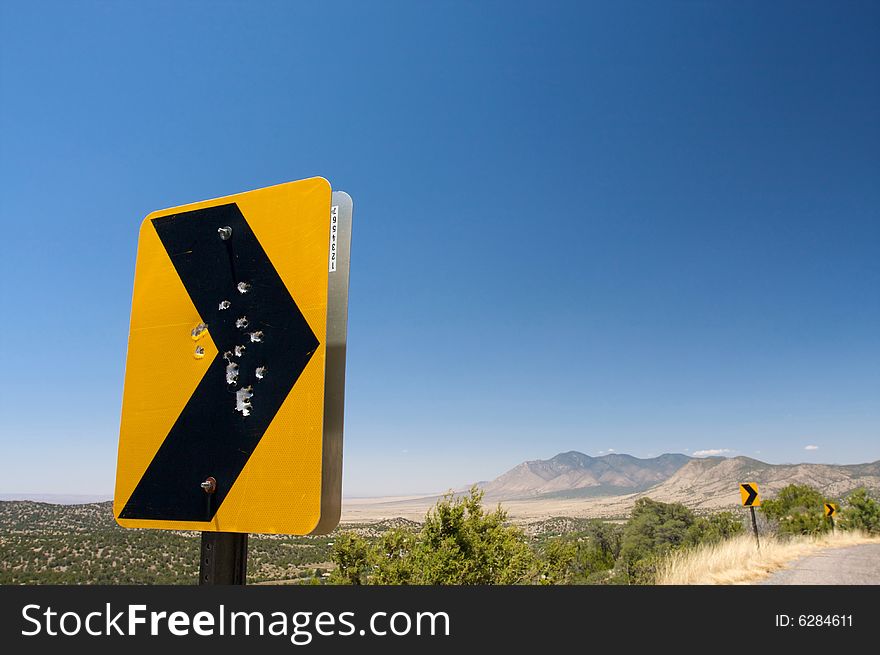 Gun shot holes through a rural road sign