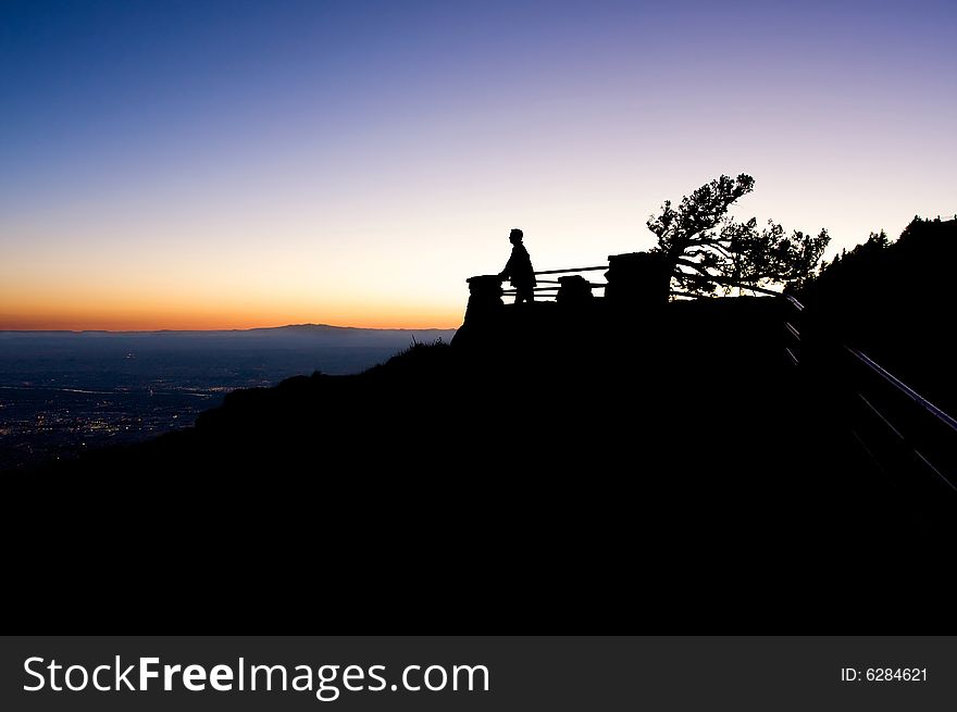 An image of a man looking out at an amazing view at sunset. An image of a man looking out at an amazing view at sunset