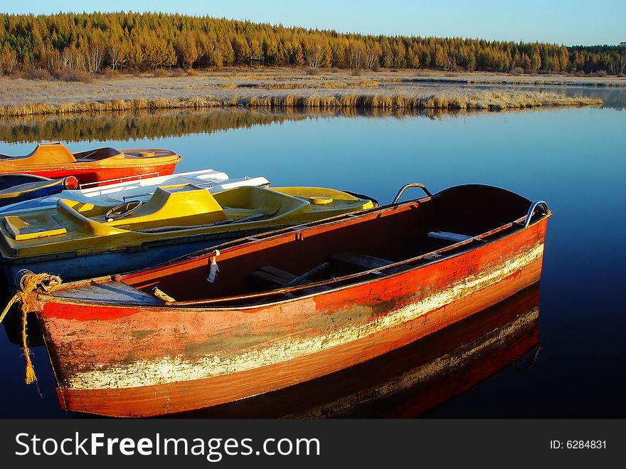 Ferreous boat in the lake in the early morning at sunrise. Ferreous boat in the lake in the early morning at sunrise