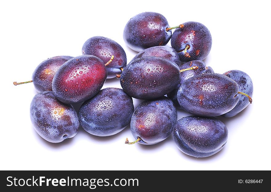 Wet plums on white background