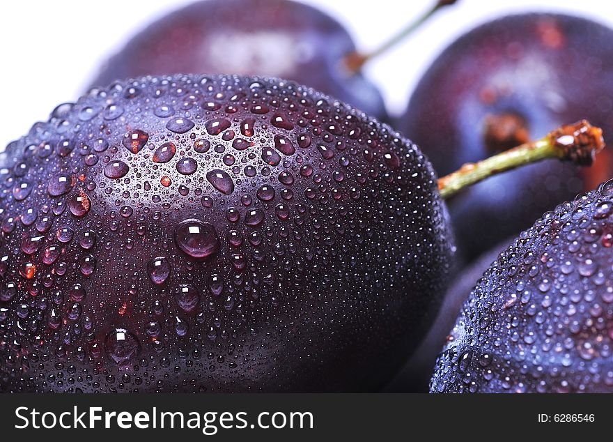 Close-up of wet plums on white background