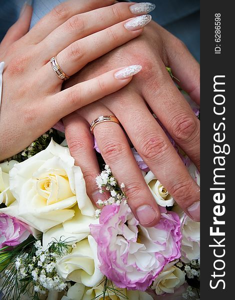 Bride and groom hands over flowers. Bride and groom hands over flowers