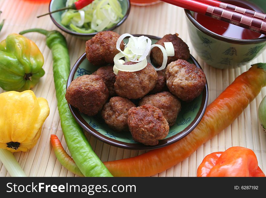 Some meatballs with leak in decorative table-ware