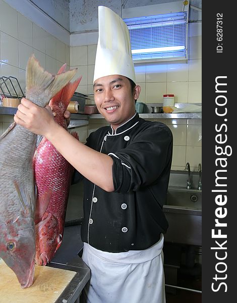 Chef holding big fish at kitchen butcher. Chef holding big fish at kitchen butcher