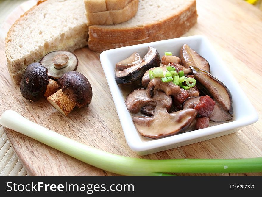 Some mushrooms in a bowl with some onions