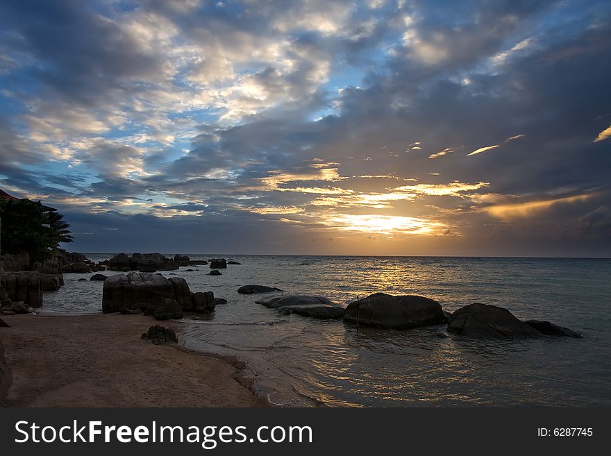 Sky on the sunset in the tropics, stones, sand and the sea