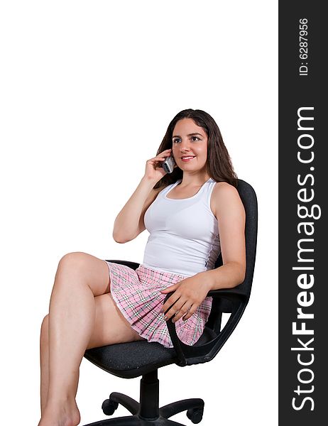 A beautiful girl, sitting on a office chair, talking over the phone, smiling. A beautiful girl, sitting on a office chair, talking over the phone, smiling