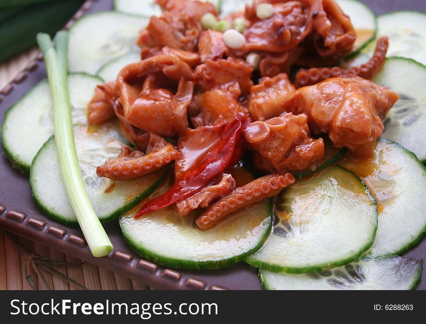 A fresh salad of octopuses on cucumbers. A fresh salad of octopuses on cucumbers