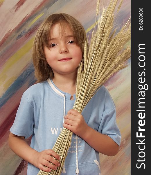 Little girl with the bouquet of wheat