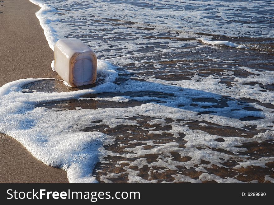 Plastic container washed up on shore at the beach. Plastic container washed up on shore at the beach