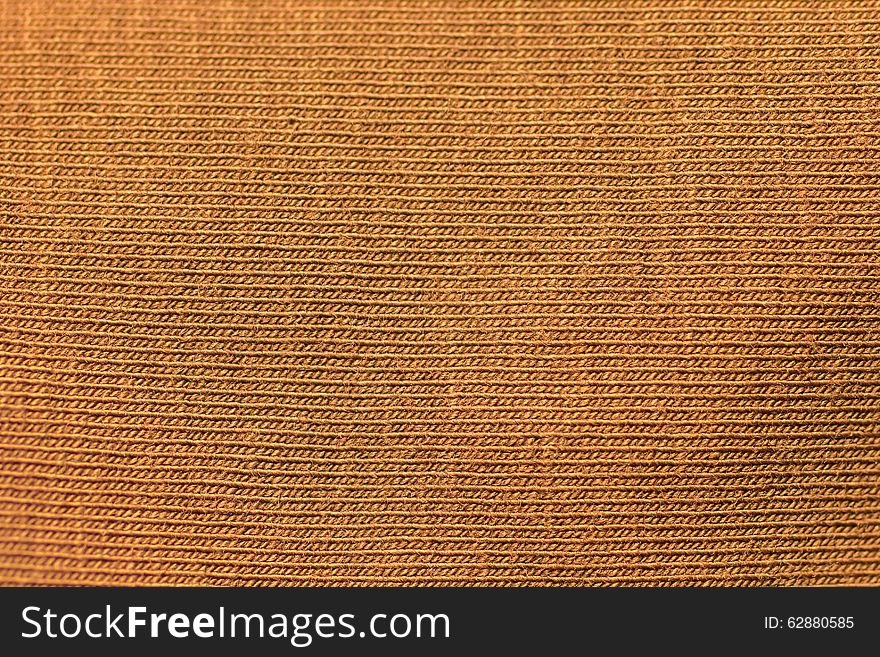 Gold unusual texture of an orange knitted fabric. Gold unusual texture of an orange knitted fabric