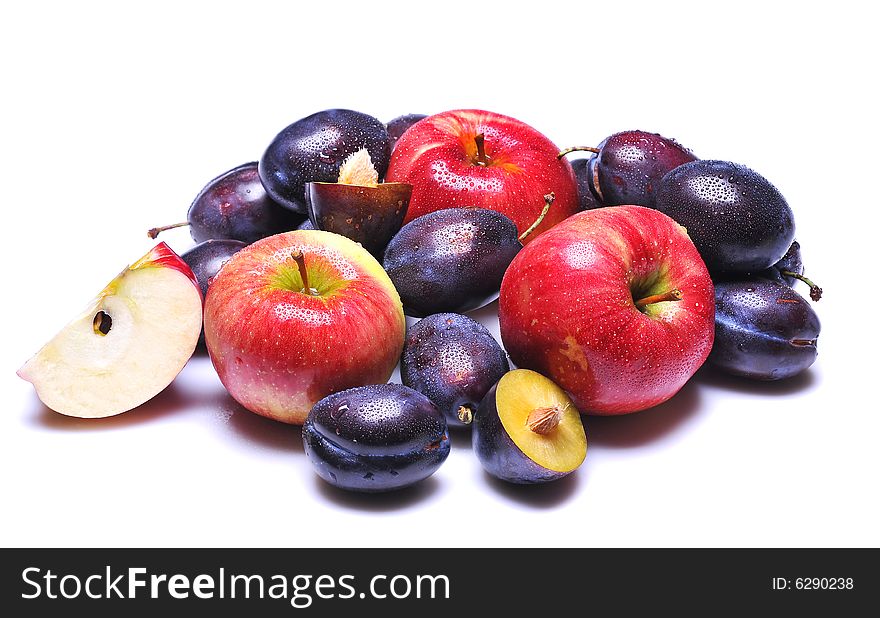 Wet plums and red apples on white background. Wet plums and red apples on white background