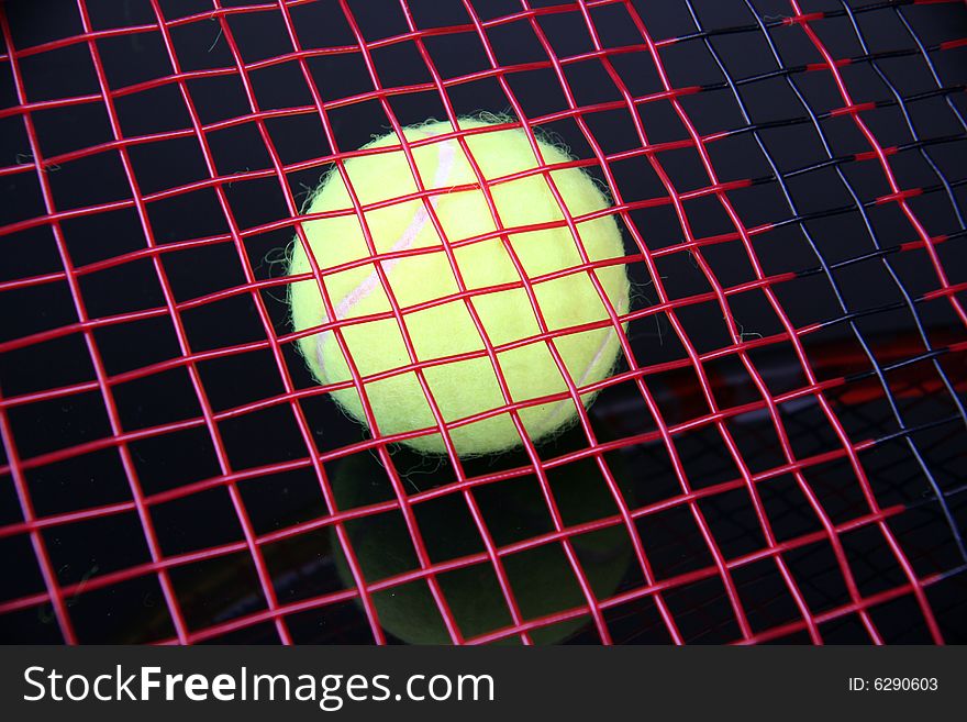 tennis ball under colored racket