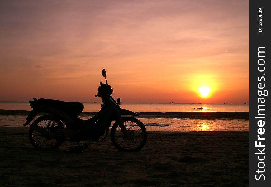 A motor bicycle on the sunset beach. A motor bicycle on the sunset beach
