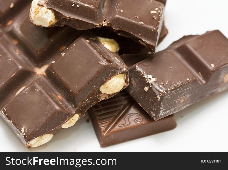 Chocolate pieces with nuts on neutral background