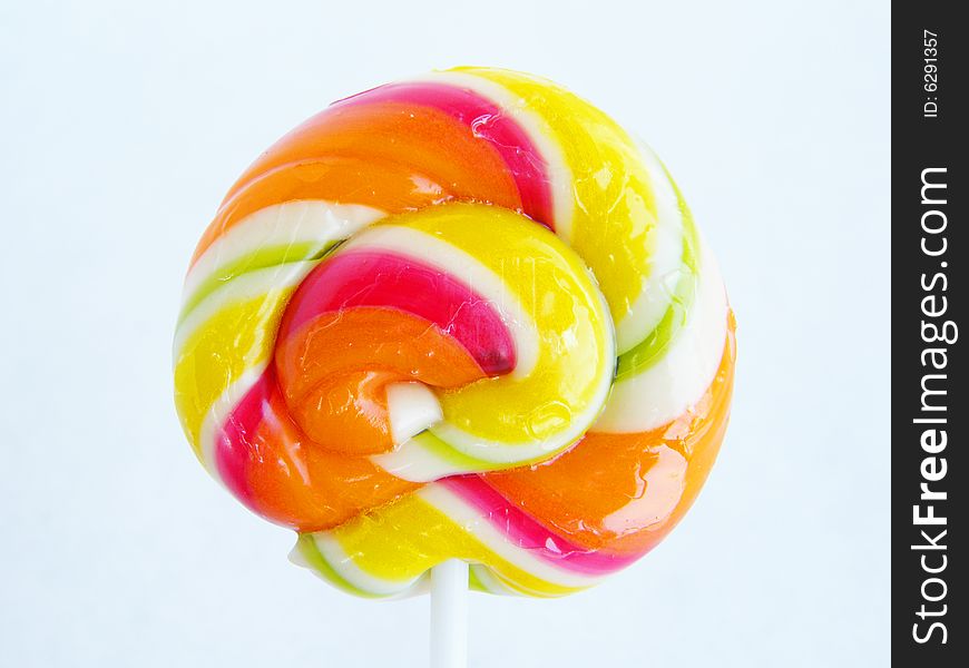 Multi-coloured a sugar candy on a stick on a white background