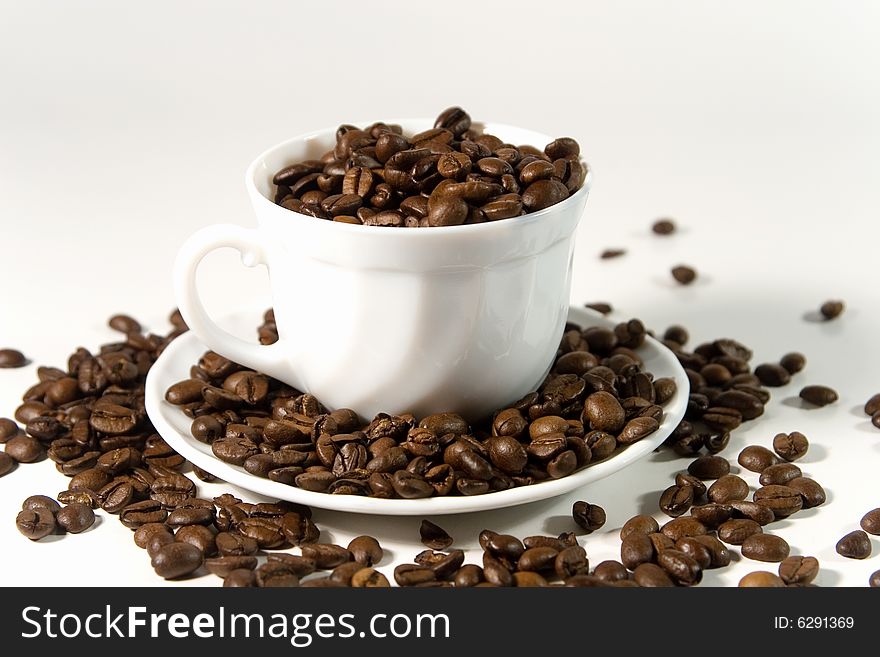White cup with coffee beans (on white background)