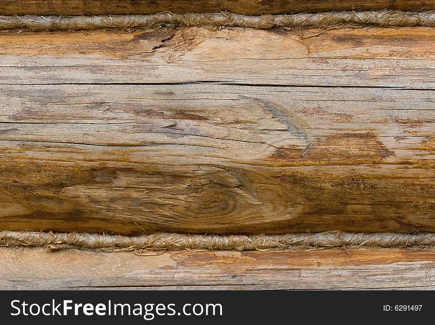 Closeup of an old wooden wall made of logs (as a wooden background)