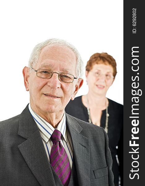 Closeup portrait off a senior businessman with colleague in the background isolated on white