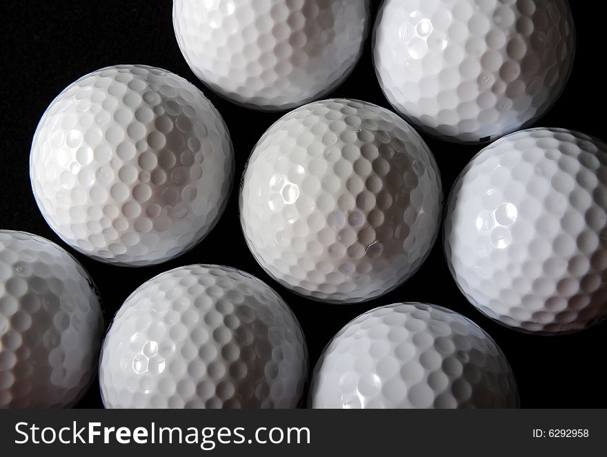 Many golf balls on the black background