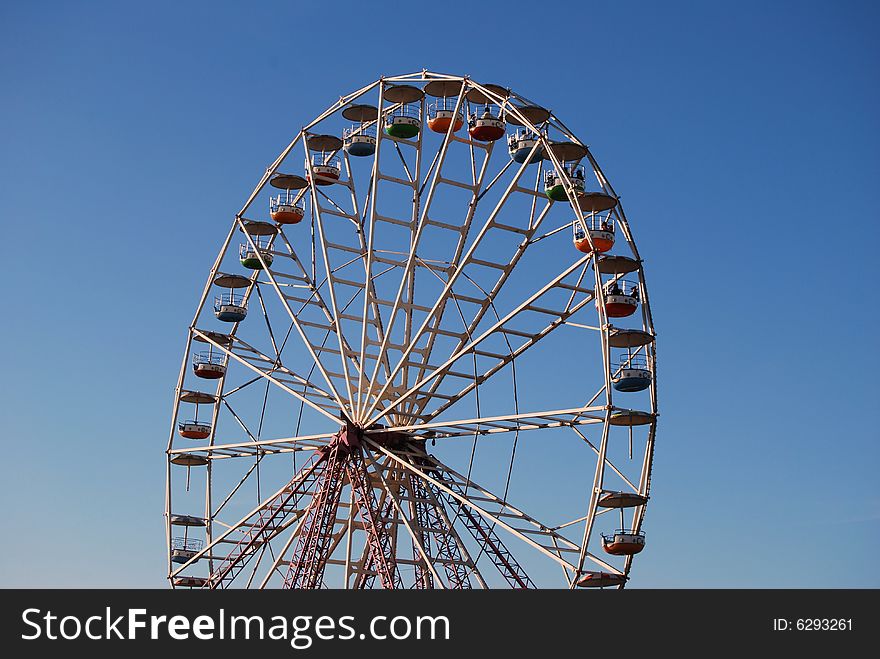 Ferris wheel on background blue sky