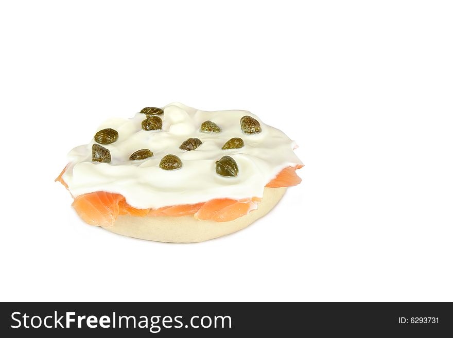 Fresh bagel and lox with sour cream and capers. Over white background.