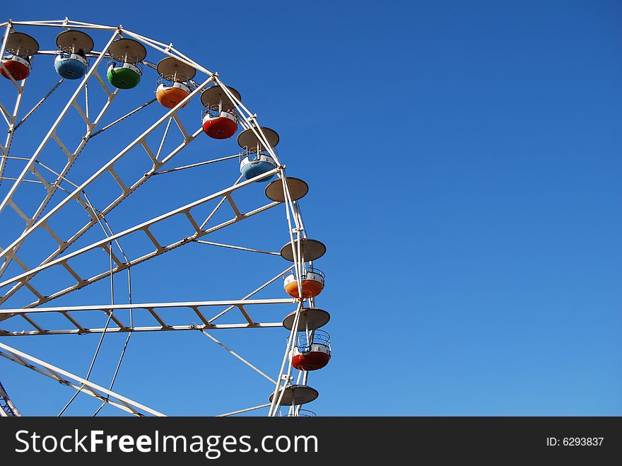 Ferris wheel on background blue sky