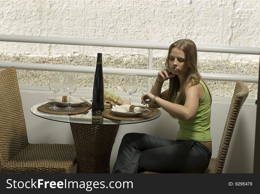 Young woman waiting for her date at a table for two. Horizontally framed shot. Young woman waiting for her date at a table for two. Horizontally framed shot.