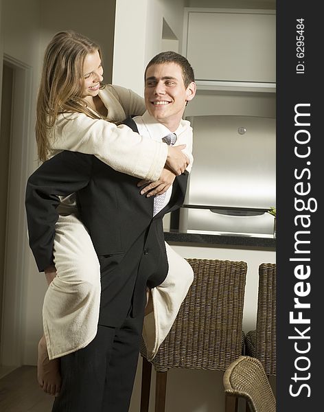 Couple smiling at each other as the man gives the woman a piggyback ride. Vertically framed photo. Couple smiling at each other as the man gives the woman a piggyback ride. Vertically framed photo.