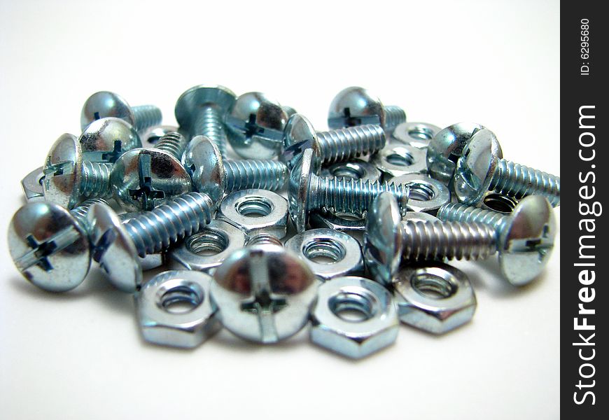 An arrangement of nuts and bolts on a white background
