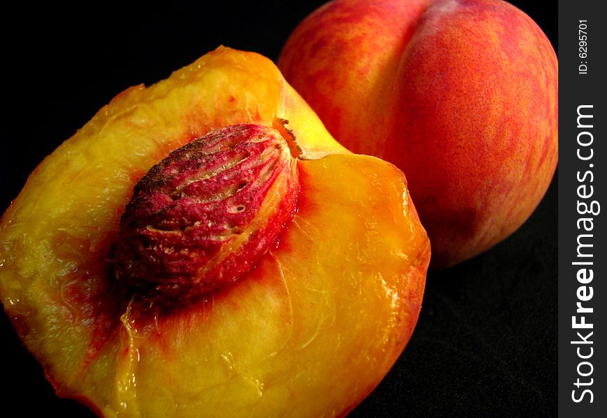 Two ripe peaches on a black background